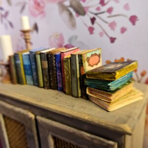 Miniature antique magical books sitting on a 12th scale armoire