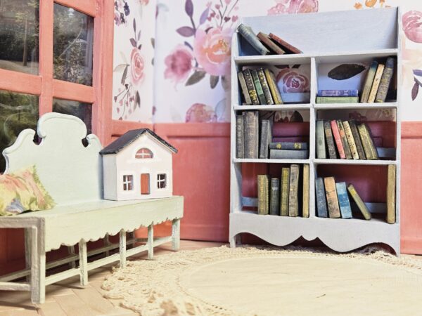 Antique miniature books sitting on a 12th scale bookcase "Josie", next to the "Janice" bench